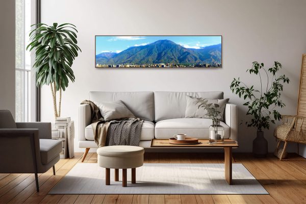 Guardian Ávila panoramic fine art canvas print displayed above a light sofa in a modern living room with wooden furniture and indoor plants.